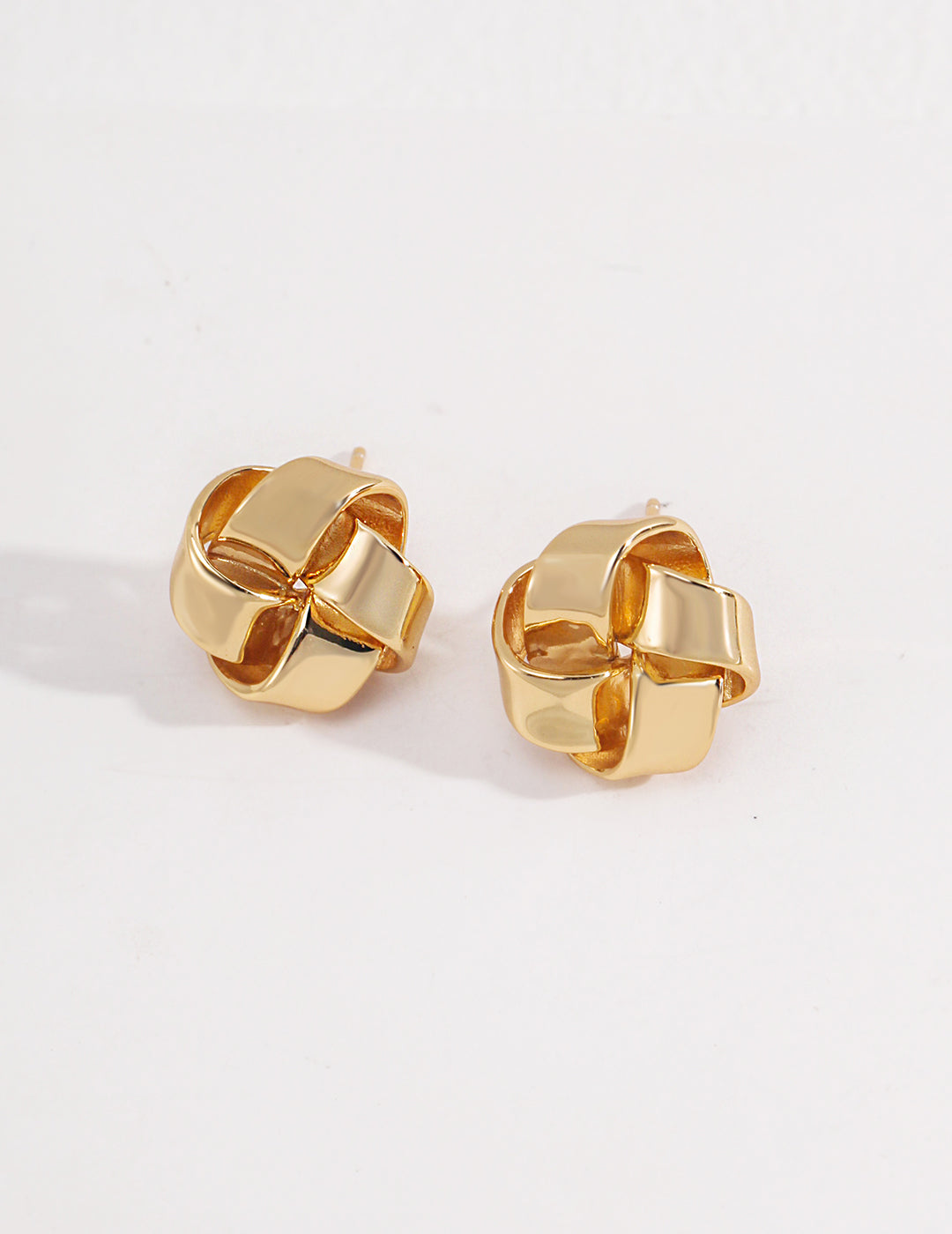 Gold knot-shaped studs crafted from 925 silver, available in vintage gold and white gold. Measuring 1.5 cm, these minimalist earrings add sophistication and charm to any look.