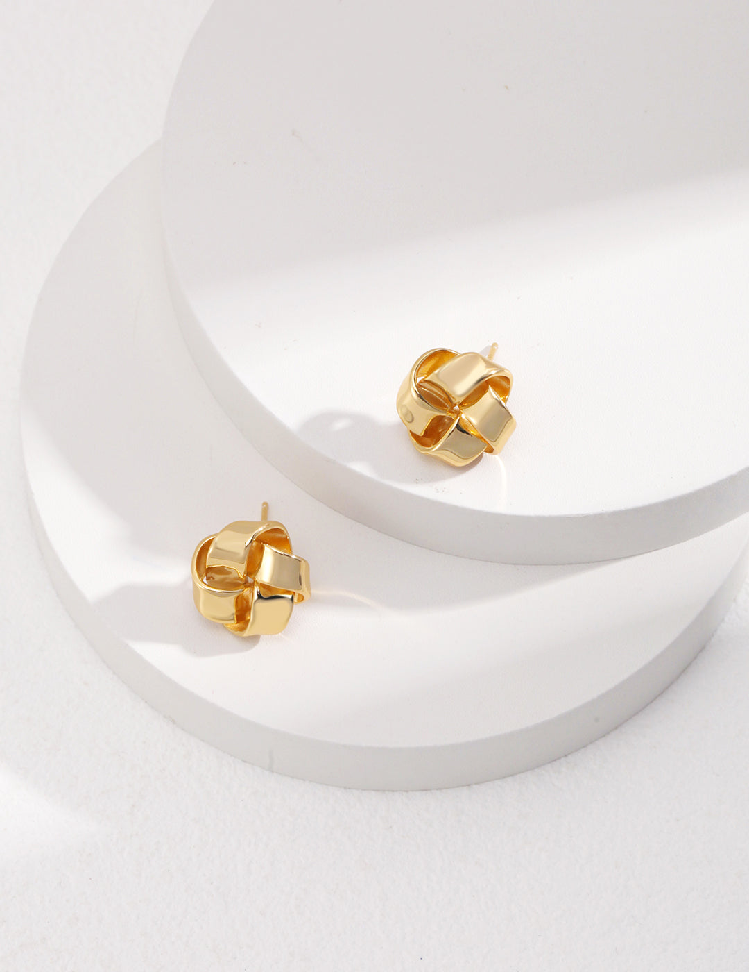 Gold knot-shaped studs crafted from 925 silver, available in vintage gold and white gold. Measuring 1.5 cm, these minimalist earrings add sophistication and charm to any look.