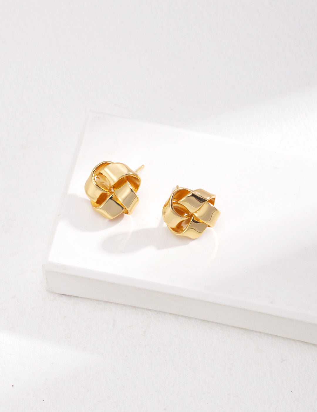 Gold knot-shaped studs crafted from 925 silver, available in vintage gold and white gold. Measuring 1.5 cm, these minimalist earrings add sophistication and charm to any look.